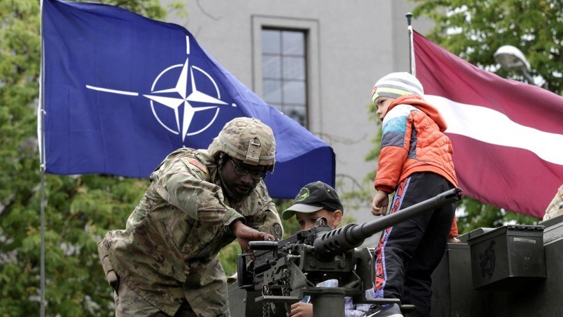 Военный НАТО в Латвии показывает оружие детям. Фото: Конт