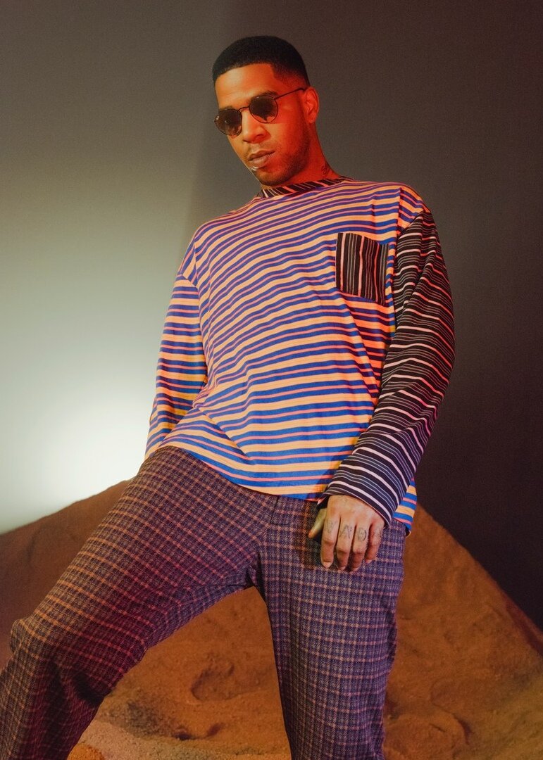 "Cudi Zone" Дизайнер Marni Франческо Риссо привнес в итальянскую моду бодрящую причудливость. Здесь он доказывает, что смелая футболка не обязательно должна иметь броский принт – нужен всего лишь оригинальный крой и контрастные цвета. Футболка с длинными рукавами, $400, брюки, $850, Marni / Солнечные очки, $183, Ray-Ban