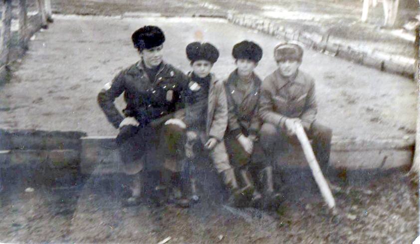 Фото из альбома автора: слева-направо: Гена Х., Гена Ж., Гена Л. (мой брат), Гена С. (с палкой) на бортике хоккейной коробки, февраль 1978 г., оттепель