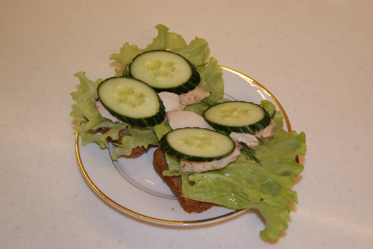 Полезный бутерброд. Чёрный хлеб, лист салата, диетическое мясо, свежий овощ, зелень.