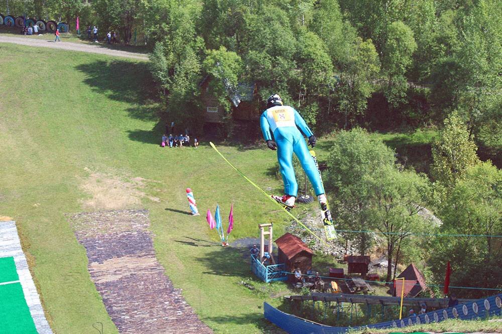 Соревнования по прыжкам на лыжах с трамплина проводят и летом: спортсмены приземляются на специальное покрытие из пластиковых щеток