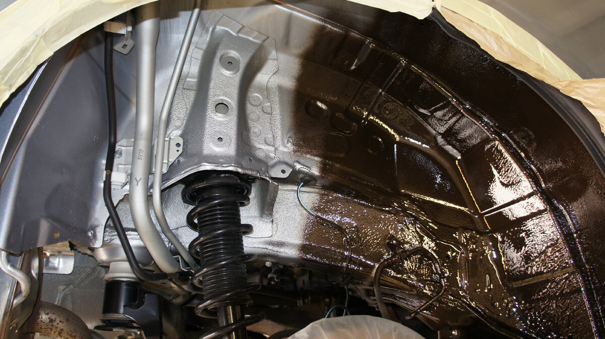 Обработка колесных арок материалом Mercasol 845 AL. Обратите внимание на границу между заводским покрытием и защитной пленкой. Еще несколько движений пистолетом — и вся арка станет темно-коричневой с «бронзовым» оттенком.  Фото Юрия Буцкого 