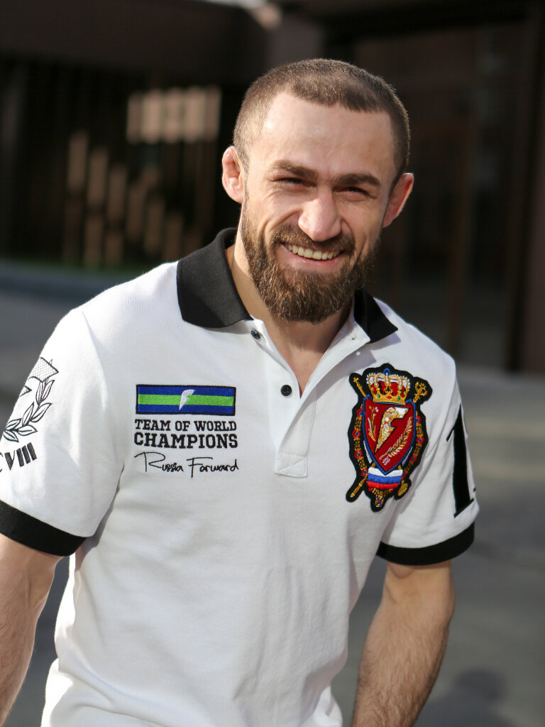 
Али Багаутинов - двукратный чемпион мира по боевому самбо в белой футболке-поло.
