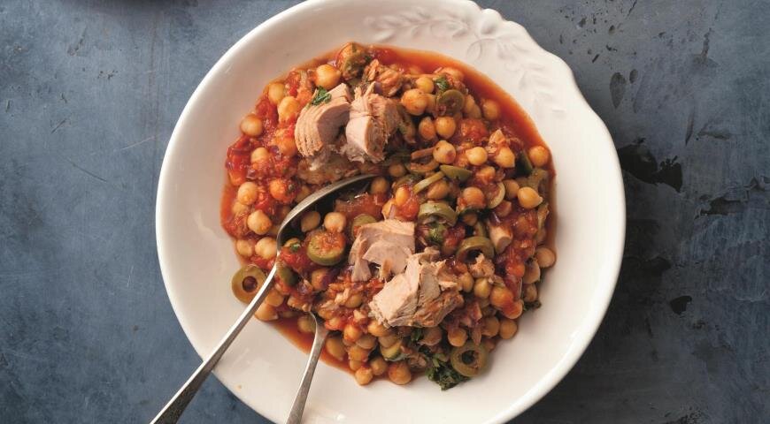 ИНГРЕДИЕНТЫ 400 г консервированного или вареного нута
400 г резаных консервированных помидоров в с/с
170 г консервированного тунца в с/с
10 оливок
1 большая красная луковица
3 зубчика чеснока
1 ст. л. томатной пасты
3 веточки петрушки
1 ч. л. красного винного уксуса
1/2 ч. л. копченой паприки или 1 ч. л. обычной паприки
4 ст. л. оливкового масла
соль, свежемолотый черный перец
ПОШАГОВЫЙ РЕЦЕПТ ПРИГОТОВЛЕНИЯ
Шаг 1
Фото приготовления рецепта: Тушеный нут с тунцом и оливками, шаг №1
Очистите и нарежьте лук маленькими кубиками, чеснок измельчите. Нарежьте оливки кружками. Петрушку мелко порубите.
Шаг 2
Фото приготовления рецепта: Тушеный нут с тунцом и оливками, шаг №2
Разогрейте 3 ст. л. масла в сковороде на среднем огне и жарьте лук до золотистого цвета, 5–7 мин., периодически помешивая. Добавьте чеснок и продолжайте жарить еще 2 мин. Положите в сковороду помидоры, томатную пасту, паприку, соль и перец, влейте полстакана воды и уксус. Увеличьте огонь до сильного и доведите до кипения. Накройте сковороду крышкой, уменьшите огонь и тушите 10 мин.
Шаг 3
Фото приготовления рецепта: Тушеный нут с тунцом и оливками, шаг №3
Нут промойте холодной водой и откиньте на дуршлаг. Добавьте в томатный соус нут, перемешайте, снова накройте сковороду крышкой и тушите 10 мин., периодически помешивая.
Шаг 4
Добавьте в соус кусочки тунца вместе с жидкостью, оливки и петрушку, полейте оставшимся оливковым маслом и перемешайте. Снимите с огня и сразу же подавайте.