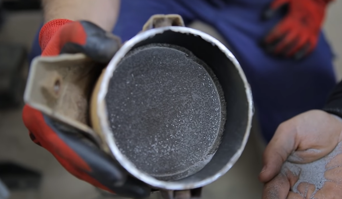 Мелкая креамическая пыль и вскрытая банка катализатора.