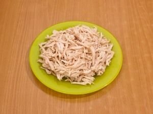     Ставим на огонь кастрюлю с водой. Куриное филе обмываем и выкладываем его в кастрюлю вариться. Готовим филе около 20 минут. Не забываем, что после того как вода закипит необходимо снять пенку и немного посалить бульон.       После того как куриное филе свариться, его необходимо разобрать на волокна.   