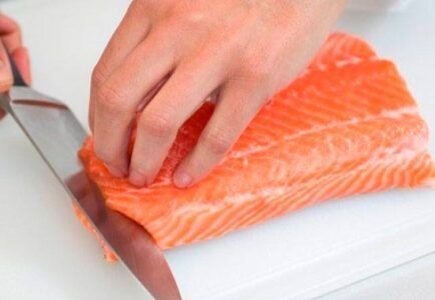     Рыбу необходимо разморозить и тщательно промыть в воде. После этого нарезаем лосось кубиками примерно 3 на 3 сантиметра. Далее выкладываем кусочки в миску, солим и перчим их по вкусу, а также обильно сбрызгиваем соком лимона. В таком виде лосось нужно выдержать 30 минут. Наливаем в кастрюлю воды и ставим ее на огонь. В момент кипения добавляем в воду кусочки лосося и сбавляем огонь до минимального. Готовим рыбу 10 минут, после чего достаем ее и остужаем.   