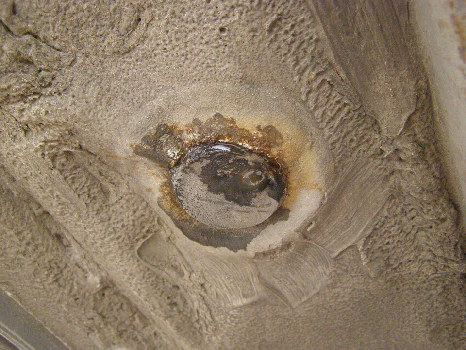 Под дренажными заглушками явный процесс коррозии и стоит влага. Откуда она там?! При нормальных условиях пол всегда должен быть сухой, а тут…