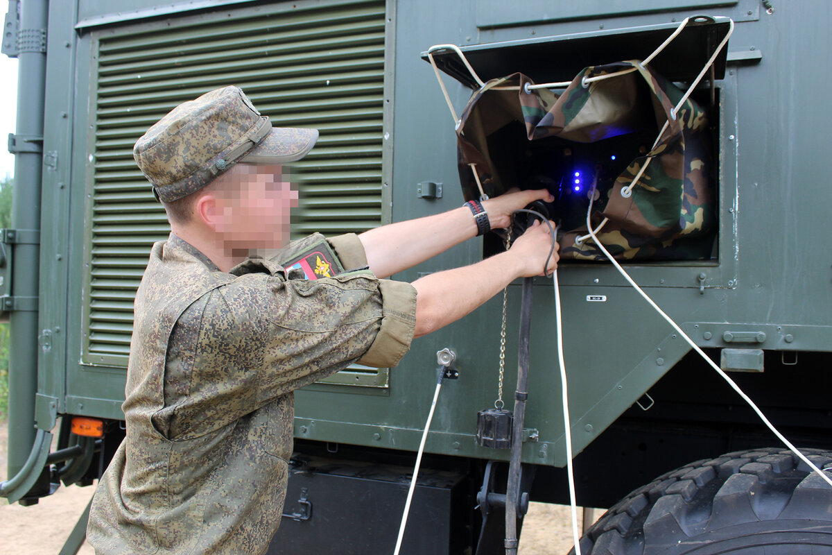 Водитель-электрик Дмитрий В. подключает аппаратуру
