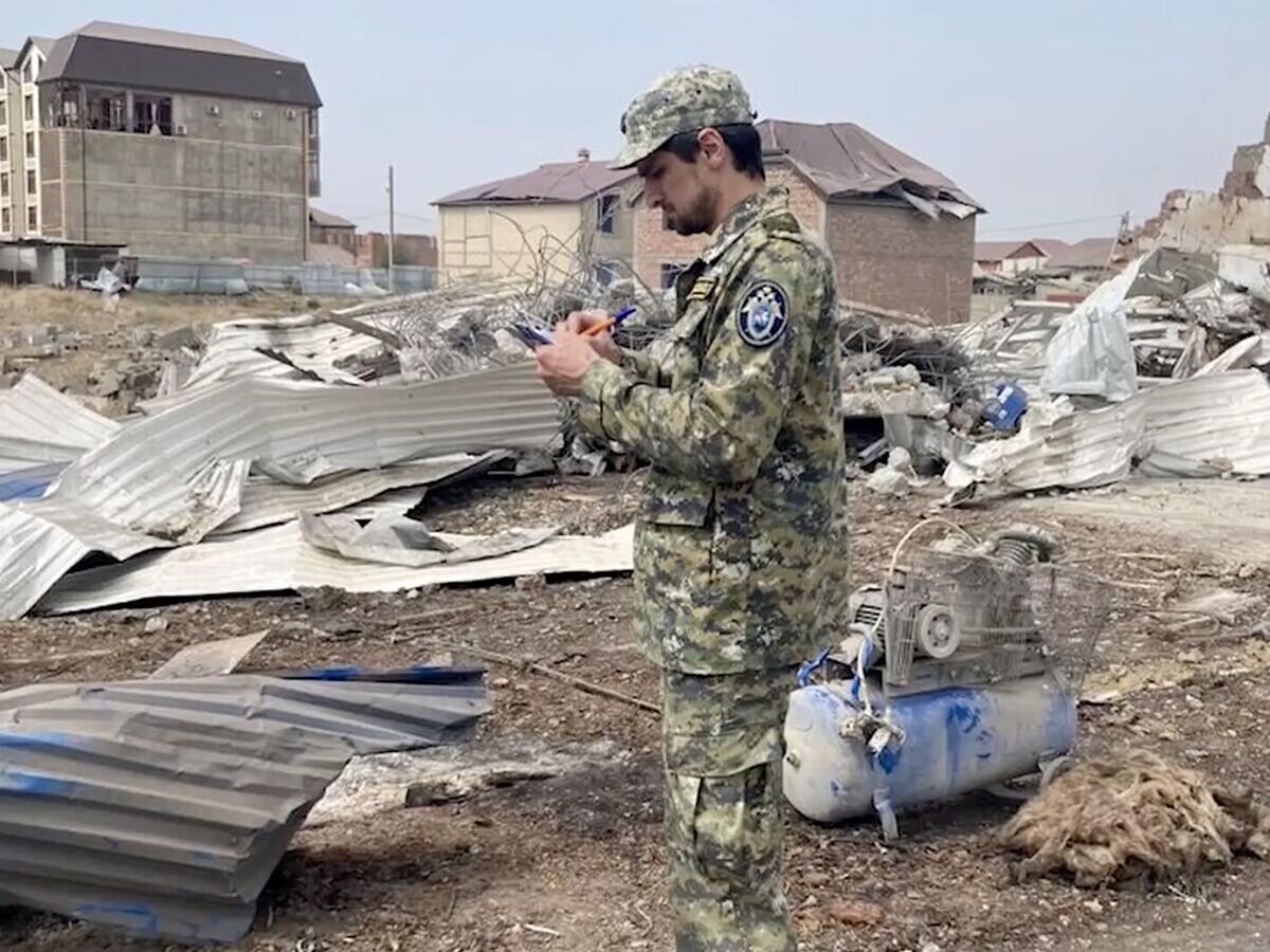    Сотрудник СК на месте взрыва в автосервисе под Махачкалой. Кадр видео© СК России