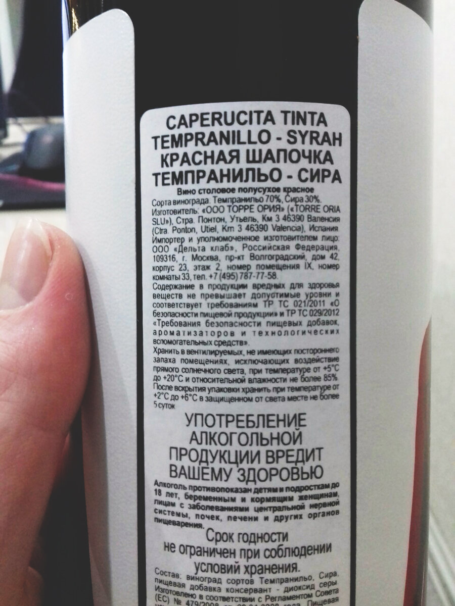 Описание вина находится по середине, между этикетками. 