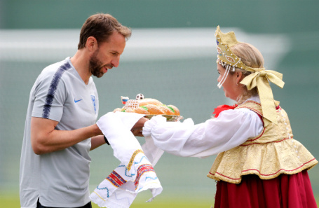 
Россия. Санкт-Петербург. Главный тренер национальной сборной Англии по футболу Гарет Саутгейт получает каравай перед началом тренировки на стадионе «Спартак» в преддверии чемпионата мира по футболу FIFA 2018. Фото: Owen Humphreys/PA Images/ТАСС