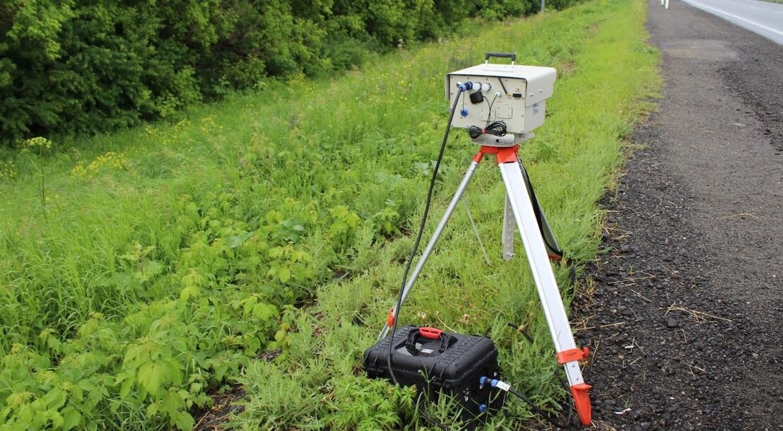 комплекс видеофиксации нарушений ПДД, установленный на треноге возле дороги