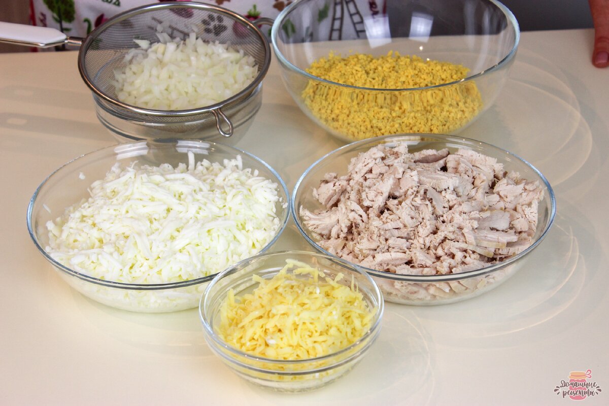 Филе куриной грудки отварить, порезать на небольшие кусочки.
Яйца сварить вкрутую, отделить белки от желтков.
Белки натереть на крупной терке, желтки на мелкой.
Сыр натереть на крупной терке.
Лук очистить и мелко порезать, залить горячей водой на 5-10 минут, чтобы ушла горечь лука, затем воду слить.  