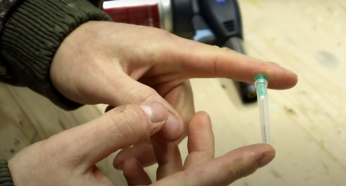 Достал иглу из упаковки со шприцем.