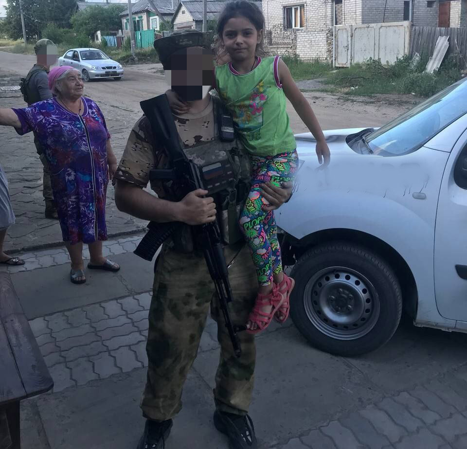  Наш боец с девочкой, освобожденной из подвала 