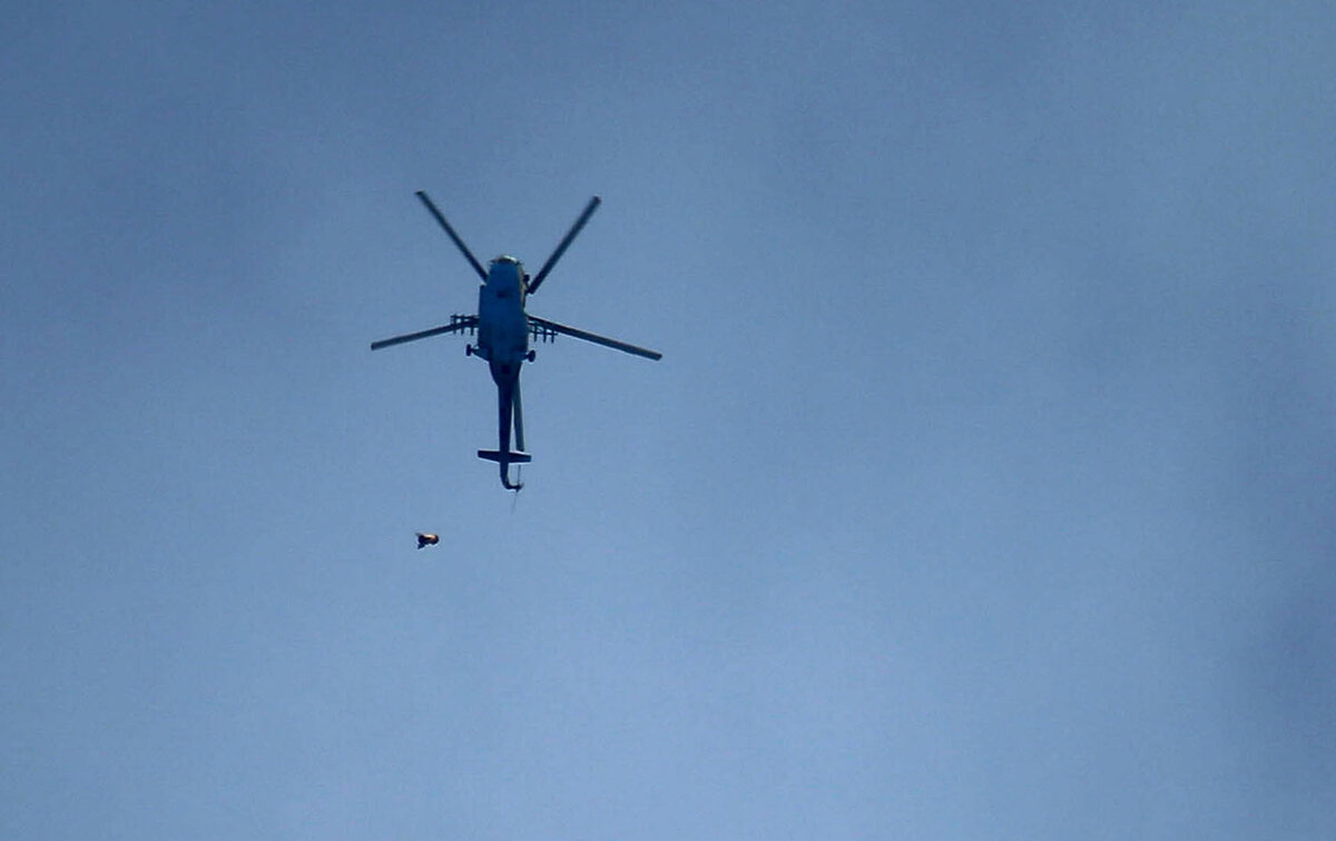 Российский боевой вертолет сирийской армии сбрасывает полезную нагрузку через повстанческий городок Арбин, в восточном регионе Гуты, 20 февраля 2018 года. 