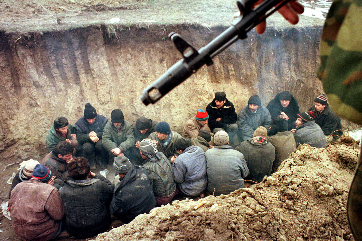 Чеченские мужчины, задержанные российскими военными в Грозном. Февраль 2000 года. REUTERS 