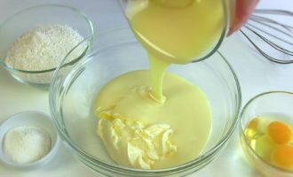 Добавить в миску масло 200 граммов, влить сгущённое молоко одну баночку.