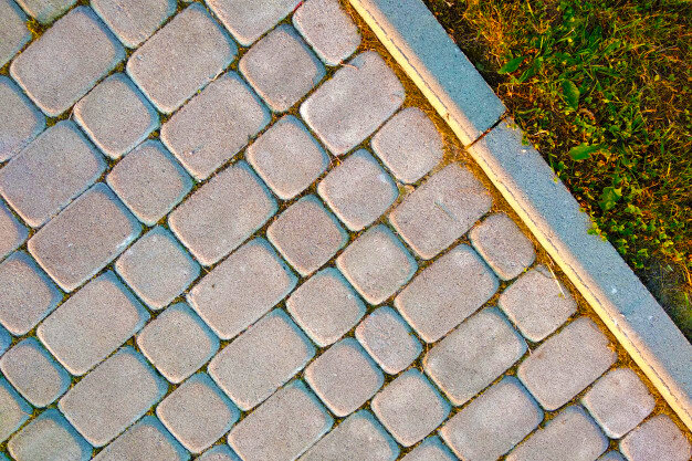 Бордюрный камень отделяет пешеходную дорожку от газона