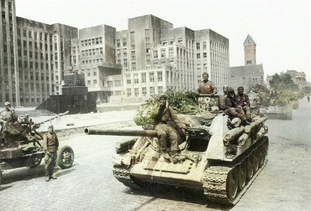 Колонна СУ-85 на площади Ленина в освобожденном Минске. На фото слева — 37-мм зенитная пушка 61-К. Июль 1944 г.