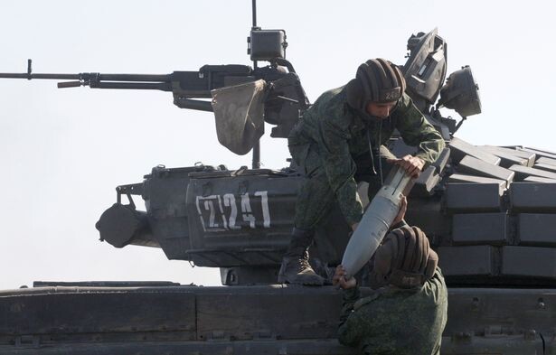 Crew members of the Luhansk People's Republic forces carry a tank shell during the biathlon (Image: REUTERS)
