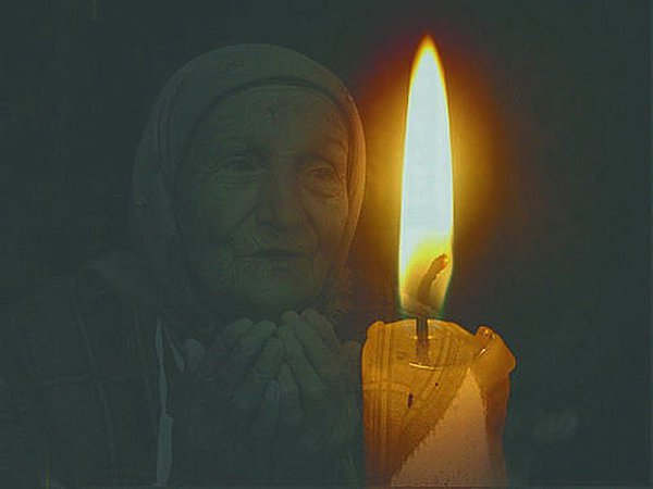Тихо догорает свеча. Мать молится. Мать молится у иконы. Свечка маме. Икона и свеча.