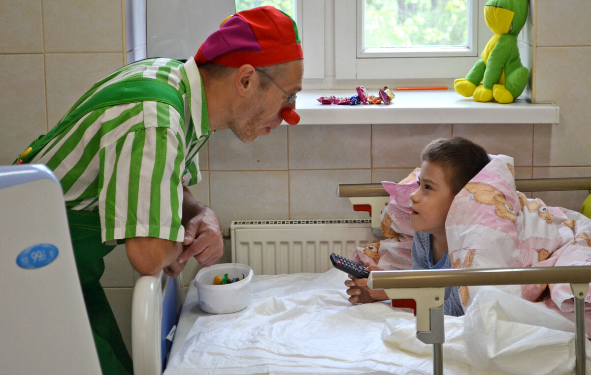 Клоун Пугги Пуговкин (Виталий Гомонюк) налаживает контакт с подопечным ребёнком. Фото предоставлено АНО "ЛенЗдравКлоун"