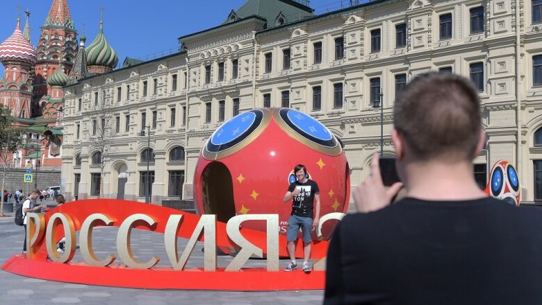 Молодые люди фотографируются рядом с символикой, посвященной предстоящему чемпионату мира по футболу 2018 года в Москве | Источник: РИА "Новости"