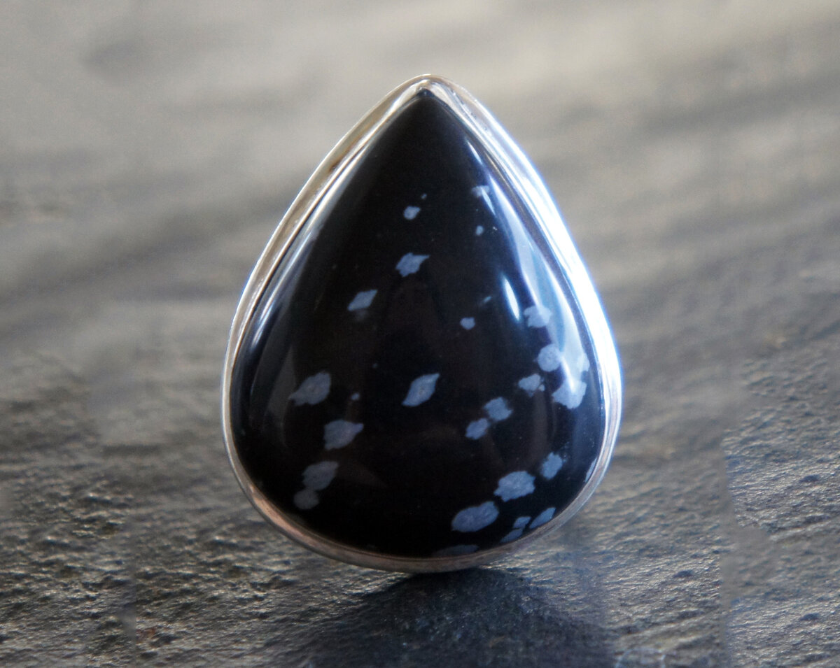 Капля обсидиана с белыми вкраплениями "снежинками".