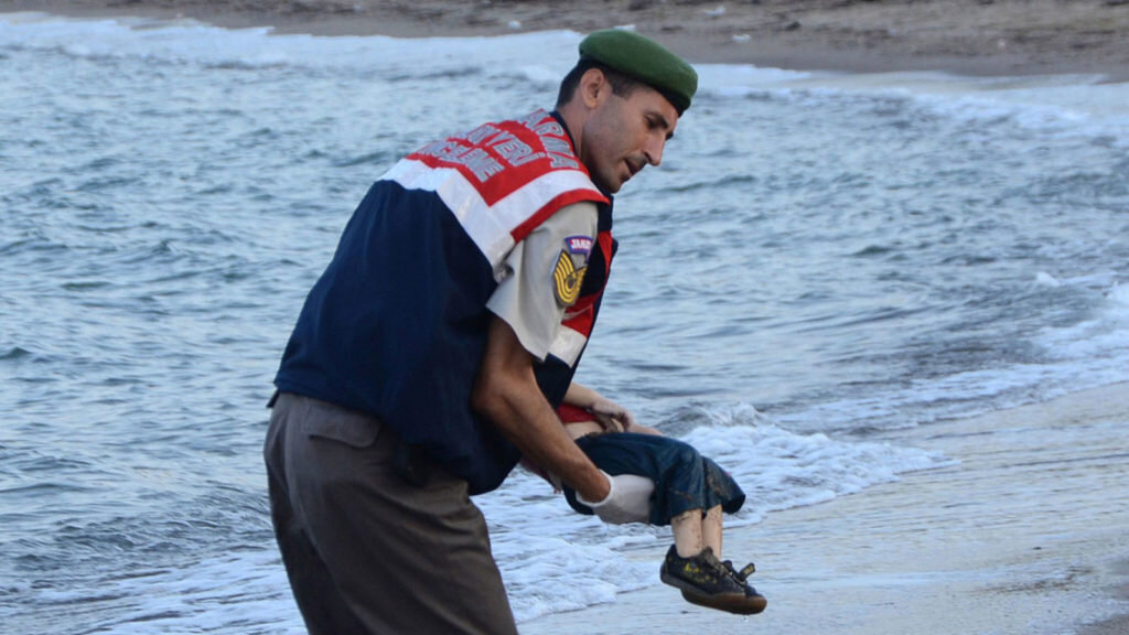 Фотография погибшего мальчика-беженца на руках турецкого спасателя.