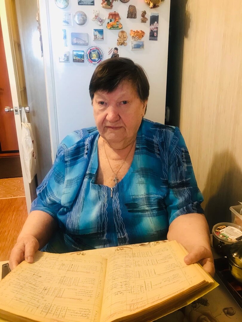 Вера Константиновна Чепкасова держит в руках тетрадь учёта матчей хоккейных и футбольных чемпионатов. 