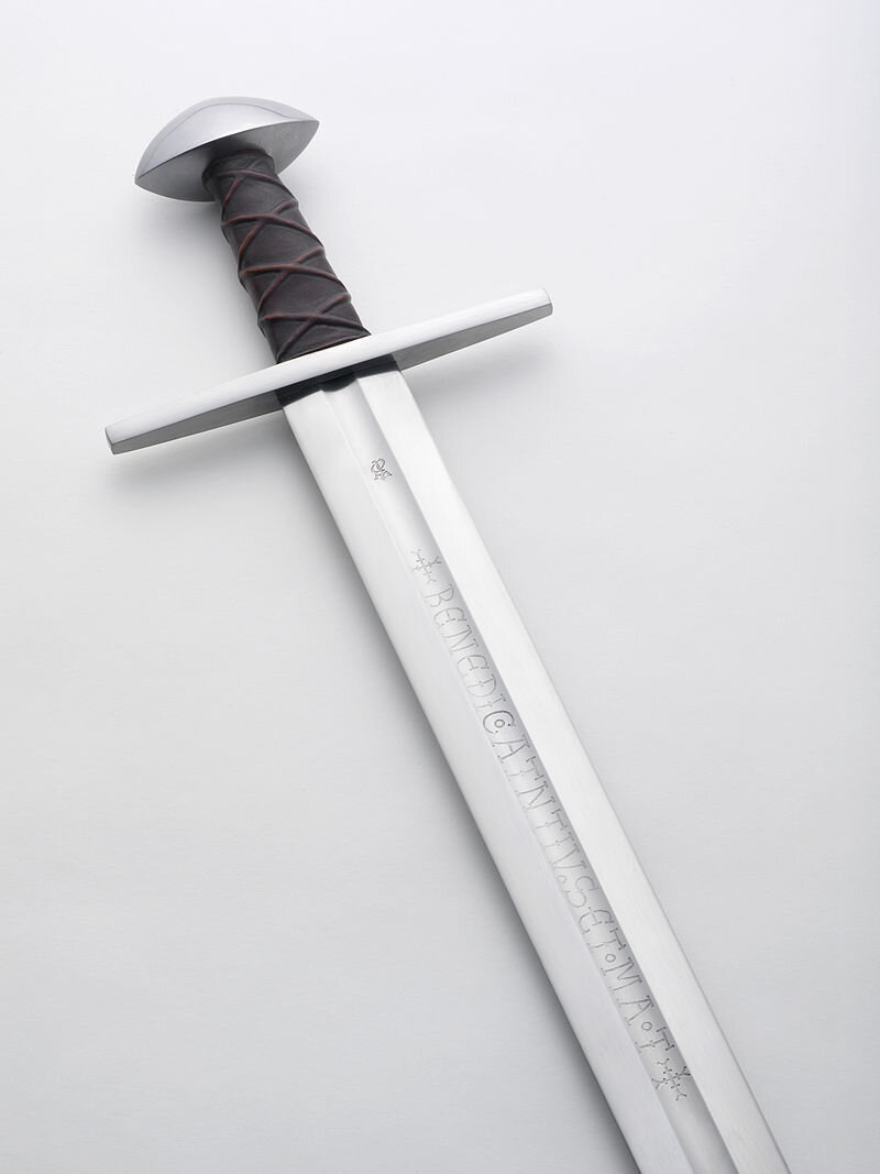 Надпись на клинке BENEDIC•ATNTNIV•SET•MA•T (реплика меча из замка Соборг) Авторство: Søren Niedziella from Denmark. Albion_Soeborg_Medieval_Sword_12, CC BY 2.0, https://commons.wikimedia.org/w/index.php?curid=28079726