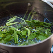 1.  Щавель вымыть, листья крупно нарезать, а оторванные стебли положить в кастрюлю, залить куриным бульоном и дать ему покипеть пять минут. После этого процедить бульон через мелкое сито и марлю (или полотенце), чтобы в нем не осталось мелких песчинок, которые могут быть на щавеле даже после того, как его промыли.