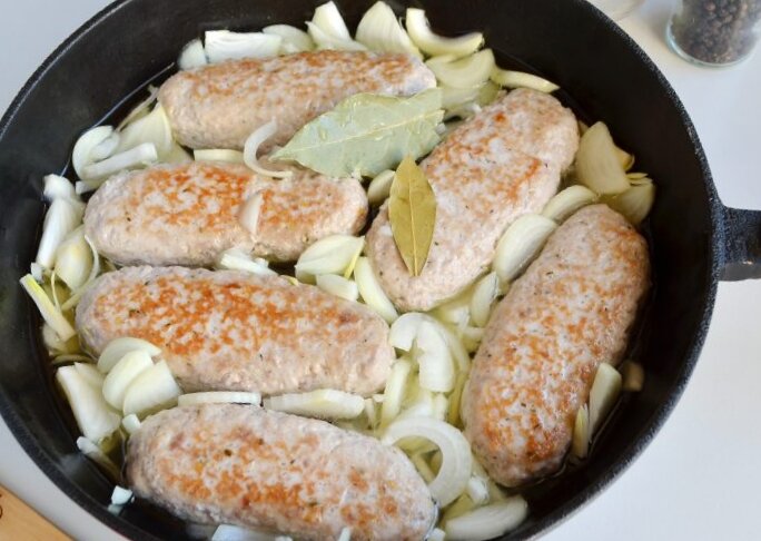 С лучком колбаски станут нежнее.