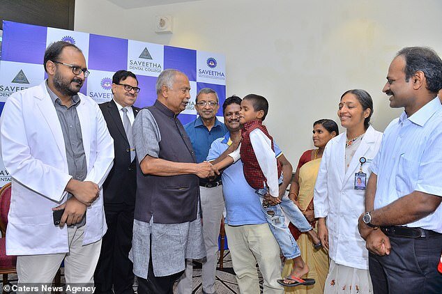 Команда врачей, Равиндранат на руках у отца, справа - мать мальчика (в желтом). Фото Daily Mail.