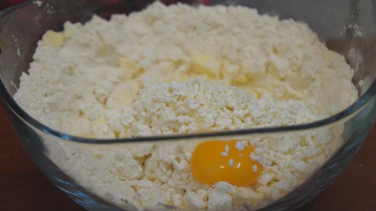 1) В просеянную муку, добавляем: чайную ложку разрыхлителя, щепотку соли, 250г сливочного масла (порезанного на мелкие кусочки), 250г творога, 2 желтка, затем перемешиваем руками
