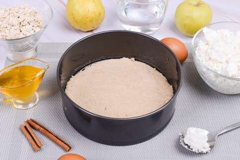 2. Перемолите овсяные хлопья с помощью блендера, переложите в миску. Добавьте белок, воду и молотую корицу, перемешайте. Выложите тесто в форму для выпекания, по краям сформируйте небольшие бортики. Готовьте 10 минут в разогретой до 180 градусов духовке.