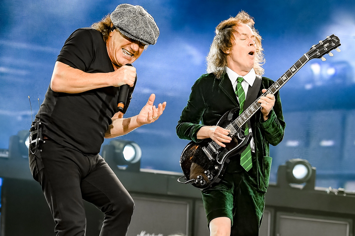 Янг ac dc. AC/DC 80s. Angus young AC/DC 70s. AC DC Angus young 2021. Гитарист группы АС/DC.