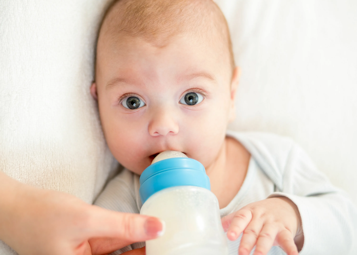 Ребенок. Младенец с бутылочкой. Кормление из бутылочки. Малыш пьет бутылочка.