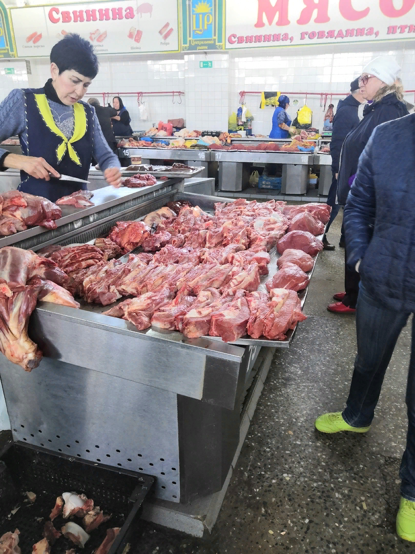 Продавщица без перчаток и головного убора очень мило режет мяско