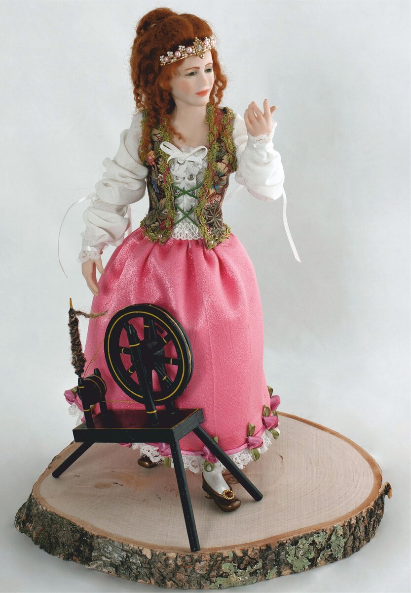 Briar Rose  (Спящая Красавица). Это полноценная скульптура 30 см в высоту, парик сделан вручную из мохера, туфли лепные. Ее одежда полностью сделана вручную и украшена розами. Ее прялка превращает шерсть в тонкую золотую нить. Она только что дотронулась до веретена и с удивлением ожидает, что же произойдет. Спящая Красавица сделана на заказ и будет выставлена в Музее Кукол в Чехословакии. Мне не хотелось делать ее спящей, потому что ее так всегда изображают. Мне хотелось побольше рассказать, ведь так много чего можно еще поведать. Briar Rose доступна в Музее Паненек (Кукол) в Чехословакии 