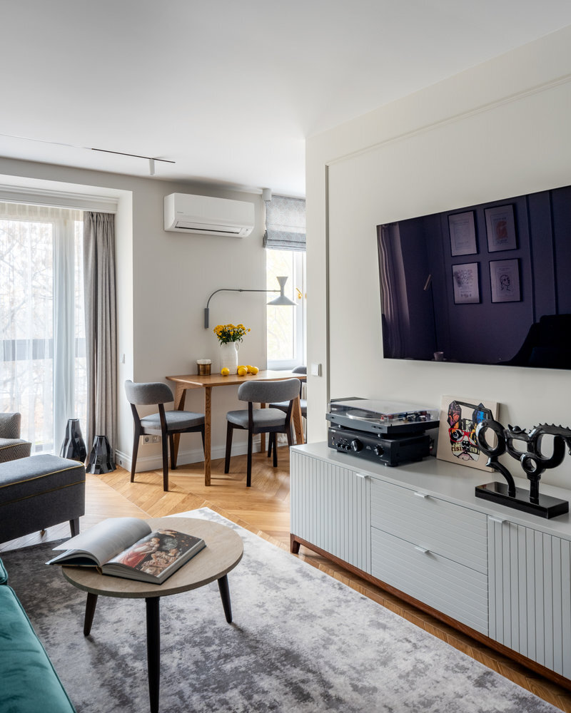 У стены напротив находится ТВ-зона. От телевизора до тумбы внутри стены проложили кабель-канал, поэтому никаких проводов не видно. 