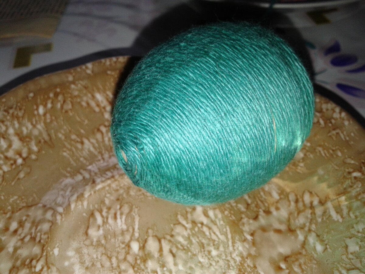 Обмотаем сырое яйцо цветными нитками.