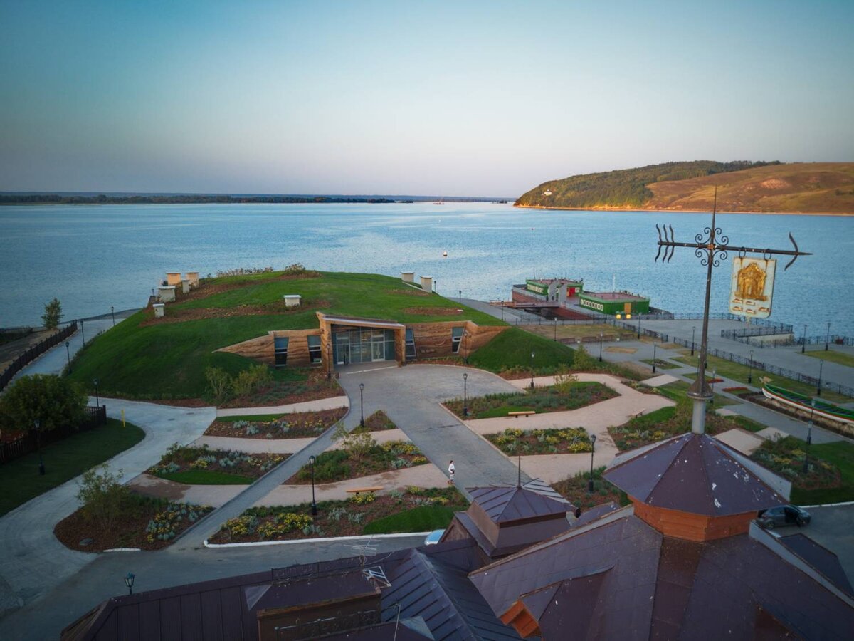 вид на музей под холмом с причала