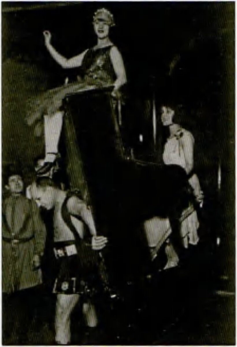 Александр Засс выполняет трюк с переносом переносом пианино с артистами