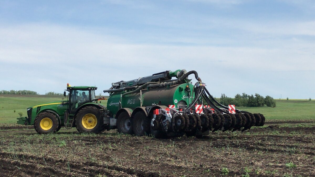 на фото изображен трактор JOHN DEERE с бочкой и культиватор с технологией STRIP TILL от компании VOLMER ENGINEERING