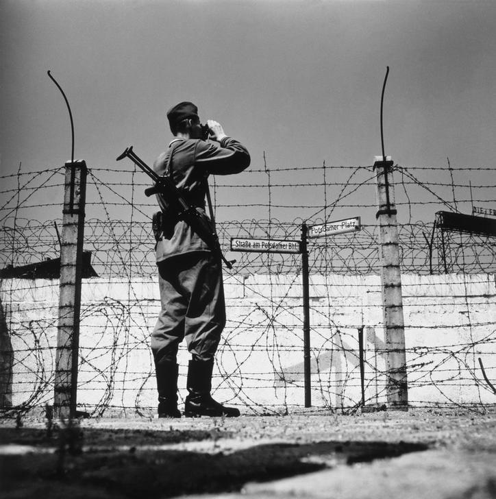 Восточногерманский пограничник наблюдает за проволочным заграждением