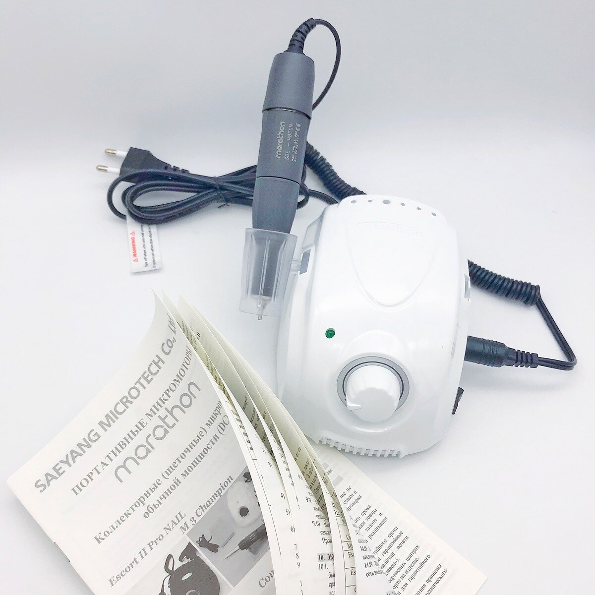 Давайте рассмотрим оригинальный аппарат Marathon 3 Champion в деталях и Вы никогда не попадетесь на уловки сомнительных продавцов.

1. Первое и основное при покупке аппарата, нужно обратить внимание на блок. На аппаратах Маратон сверху должно быть написано Marathon, такая надпись хорошо видна и пропустить ее нельзя.

2. Необходимо осмотреть блок и качество пластика блока, все детали аппарата должны быть хорошо собраны и подогнаны. Блок по ощущениям должен весить примерно 1.5 кг. Часто китайские копии весят меньше килограмма.

3. На боковой стороне блока находятся клавиши включения и  реверса. На задней стороне блока Маратона располагается переключатель режима (ручное/педаль), гнездо для педали и кнопочка 220/110 v.

4. Часто на копиях Мarathon кнопка переключения режима 220/110 V отсутствует, такие аппараты не будут работать например в USA.

5. На дне блока есть наклейка Marathon с необходимыми данными и характеристиками блока.
    Самым Важным в наклейке является индивидуальный серийный номер, который присваивается аппарату. По этому номеру заполняется гарантийный талон на Marathon,  данные по любому аппарату может отследить и проверить производитель.

 6.  На шнуре питания у аппарата Маратон 3 есть надпись HYUNDAI и ни чего удивительного, этот провод производится концерном не только для аппаратов на рынке Кореи. Так же на шнуре есть специальная белая бирка с красной надписью. Обратите Внимание!!!

 7. На блоке питания Марафона Champion имеются углубления для подставки ручки, так называемый стаканчик. Ставится такой стаканчик  с любой стороны аппарата. Еще на блоке есть специальные отверстия для фрез,  куда удобно поставить фрезы постоянно нужные под рукой.

9.  Посмотрим на ручку аппарата Marathon. 
Ручки Marathon 3 Champion отлично собраны с применением качественного пластика, который комфортно держать в руке. На ручке, четкой гравировкой нанесено название, модель, максимальное количество оборотов и серийный номер.
Надписи на ручке должны быть хорошо читаемы.

10. Коробка от Marathon 3 Чемпион должна быть фирменной, коричневой, со значком Ростеста и надписью Marathon/

11. Комплектация Marathon 3 Champion   
В комплект аппарата входят:
- блок управления Marathon-3 Champion:
- наконечник (ручка) SDE - H35LSP ;
- держатель наконечника (стаканчик);
- Инструкция/гарантийный талон.
