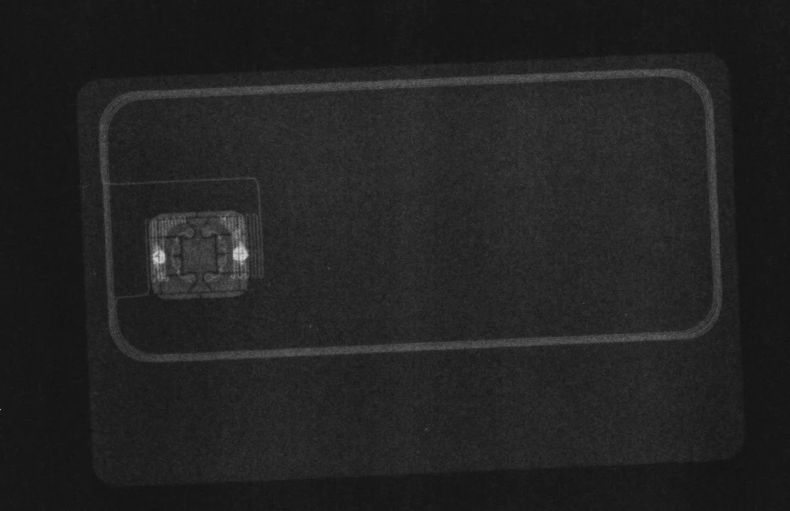 Так выглядят чип и антенна банковской карты на просвет - можете проверить свою, обычная бытовая лампочка дает достаточную яркость, варианты исполнения антенны могут различаться